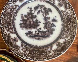 This antique transferware plate features the "Corean" pattern, manufactured by Podmore, Walker & Co. in Staffordshire, England between 1834 and 1859.It is decorated with a black or mulberry-colored oriental pagoda scene on white ironstone