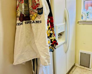 2nd refrigerator in laundry with lots of aprons  