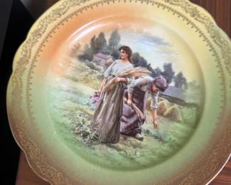 This antique decorative plate appears to be from the Imperial Crown China factory in Austria, featuring a hand-painted scene of women in a field.