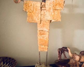 This Southwestern Shaman sculpture by artist John Gutierrez is a mixed-media piece featuring a figure draped in textured, painted burlap