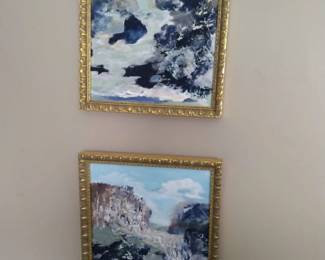 Oil paintings framed coastal scenes.