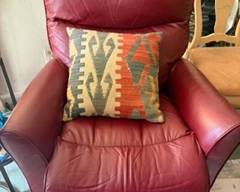 Soft leather recliner in a redish wine color. 