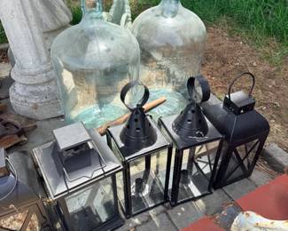 Decorative garden and farmhouse-style décor- including vintage glass carboys, decorative metal lanterns, bird baths