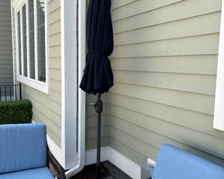 Umbrella with stand near the cast aluminum patio set