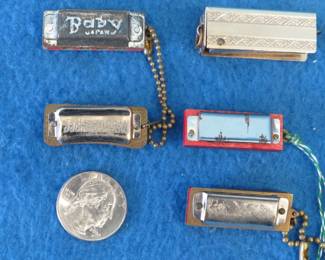 Lot 165. Five mini novelty harmonicas: Medal Butterfly 4-hole in a hinged metal case. Sounds great. Made in occupied Japan. Unknown maker 1 3/8 inches. Poor sound. Unknown maker "Jackie Coogan" 1 3/8" 4-hole with poor sound. Page 585 of the Whitman book. Unknown maker 'Elvin" 4-hole harmonica. Sounds great. Unknown maker "WHW" 4-hole harmonica with poor sound.