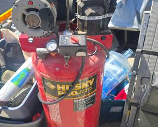 Husky Pro cast iron air compressor with a red cylindrical tank