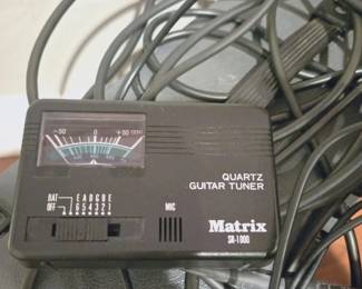 Matrix SR-1000 quartz guitar tuner featuring a black analog needle display.