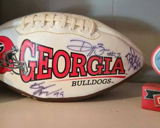Georgia Bulldogs logo football features prominent black sharpie signatures, including D.J. Shockley (#3).
