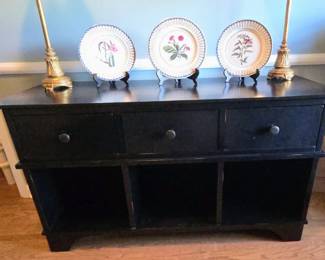 black Ballard Designs console table features three drawers and three lower open compartments