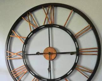 Large copper roman numeral wall clock on black metal