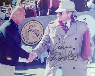 Framed historic photo autographed by Vince Dooley. Image captures two of the most iconic figures in Southeastern Conference (SEC) football history: Georgia Bulldogs head coach Vince Dooley & Alabama Crimson Tide head coach Paul "Bear" Bryant The Meeting: Pictured here are a 32-year-old Vince Dooley and a 51-year-old Bear Bryant shaking hands during the annual SEC football convention in Atlanta in January of 1965.