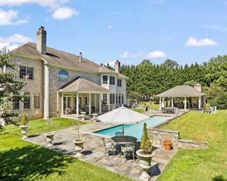 Backyard with assortment of planters, statues, dining sets, bar, fire table, patio furniture, etc.