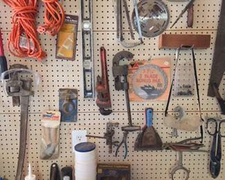Collection of tools and hardware on peg wall and on work table