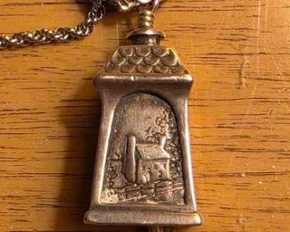 Sterling silver commemorative bell necklace with scenes depicting Mathews County life