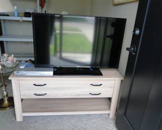 Flat screen TV, and DVD player, all sitting on a nice table