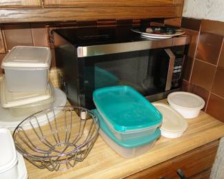 Plastic storage items, metal bread basket, and a working microwave