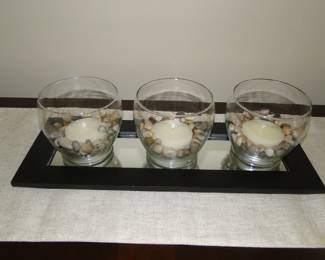 Trio of candle and rocks on mirror