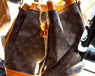 A whole table full of handbags and wallets.