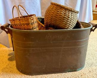 Antique copper wash bin filled with handmade baskets.