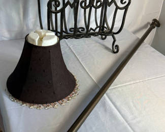 Lot 27: Ornate black iron magazine rack, decorative lampshade, and curved curtain rod
