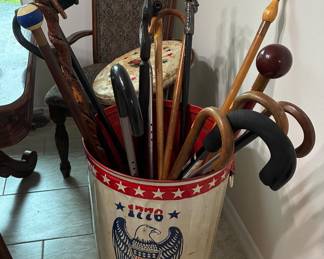 Bicentennial trashcan with lid, full of vantage canes and walking sticks