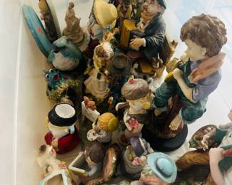 Extensive collection of porcelain and resin figurines featuring children, musicians, animals, seasonal decorations, and decorative display pieces. This charming assortment includes hand-painted figures in a variety of themes and styles,