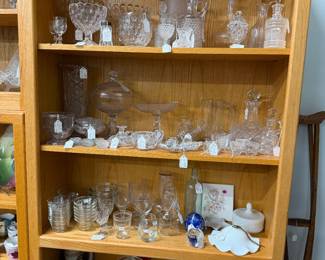 Shelving with lots of clear glass items. 