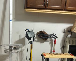 Left to right: floor to ceiling adjustable pole shower caddy with 3 bins; tripod base work light $25; workmate folding work bench; baseball glove $75