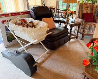Guitar, baby bassinet, recliner, end table, table lamp, arm chair, silk flowers