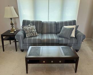 $200.00: **Sofa — blue/gray striped, rolled arms, bun feet, very clean -$200 .Sofa is 7" long x34"W x 21" deep x 24" tall **Coffee table - dark wood with inset tile/slate top, drawers, lower shelf, really nice piece -$75. 46" x 20" **End table - dark wood, simple but matches the coffee table $35 10"x 8" **Table lamp - classic brass urn style with cream shade -$25 Condition: Very good