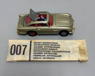 View of the vintage Corgi Toys 1:43 scale model of the James Bond Aston Martin DB5, specifically the model #270, made in Great Britain; shown with original Corgi Toys "Secret Instructions" envelope.