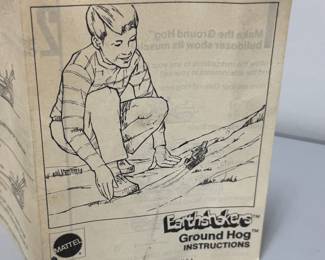 Closeup of original instructions with the set of vintage 1970 Mattel Hot Wheels Sizzlers Earthshakers toys, specifically featuring the Ground Hog dozer with various construction attachments; the set includes yellow bulldozers, detachable scrapers, dumpers, and a hitching bar for connecting different units.