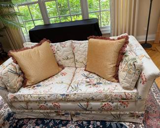 One of 2 floral quilted chintz loveseats