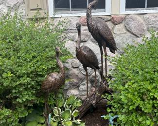 A single bronzr Crane and two bronze cranes on log, both are plum to be fountains