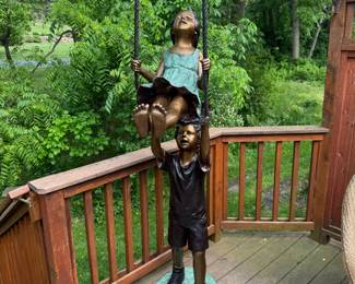 Bronze girl and boy, boy, pushing girl and swing