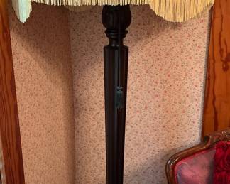 Tall, antique floor lamp with cream fringe shade in main house