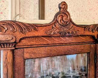 Decorative top on curved glass China hutch in main house