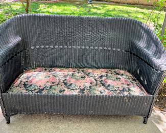 Black wicker sofa in garage