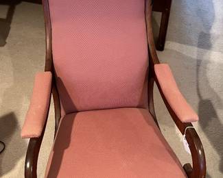 Antique pink upholstered wooden rocking chair in guest house