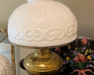 Brass hurricane lamp with milk, glass shade in main house