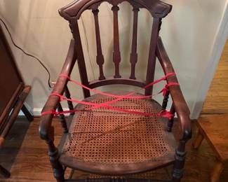 c.1860 armchair with caned seat, fondly remembered by friends of the family as the one chair that was never used,  supposedly because it was rumored that President Lincoln, at one time,  had used this chair. Because of this tradition, the red ribbon was never removed. r at one time 