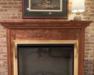 Traditional Wooden Fireplace Mantel with Ornate Carving and Brass Trim