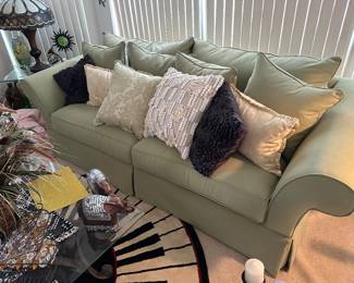Green upholstered sofa & decorative pillows
