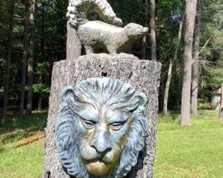 Cement skunk and lion garden statue