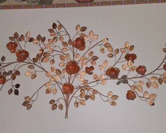 vintage metal floral wall sculpture features copper flowers and brass-colored leaves, often associated with MCM (Mid-Century Modern) style