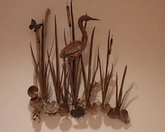 driftwood sculpture resembles rustic folk art, featuring carved wooden herons or crane arranged on a natural branch.