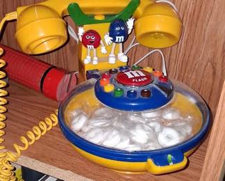 vintage M&M's collectible telephone features a integrated yellow base with a clear candy dish covered by a dome lid