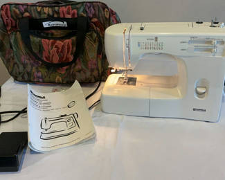 Lot 22: Kenmore sewing machine with manual, power adapter, and floral carrying bag