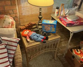 Second wicker end table with Raggedy Ann doll and board games