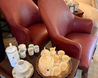 Matched set of leather club chairs with metal casters, drop-leaf side table shown with English tea sets and Baleek china cream and sugar